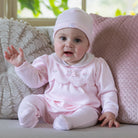 Baby girl wearing Emile et Rose Matilda pale pink romper and hat set