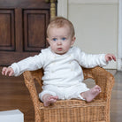  Baby boy wearing the Emile et Rose Marshall ivory velour romper while sitting