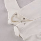 Close-up of the popper fastening on the Emile et Rose Marshall baby boys all in one occasion romper