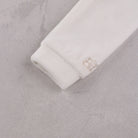 Close-up of the soft ivory velour sleeve cuff on the Emile et Rose Marshall romper
