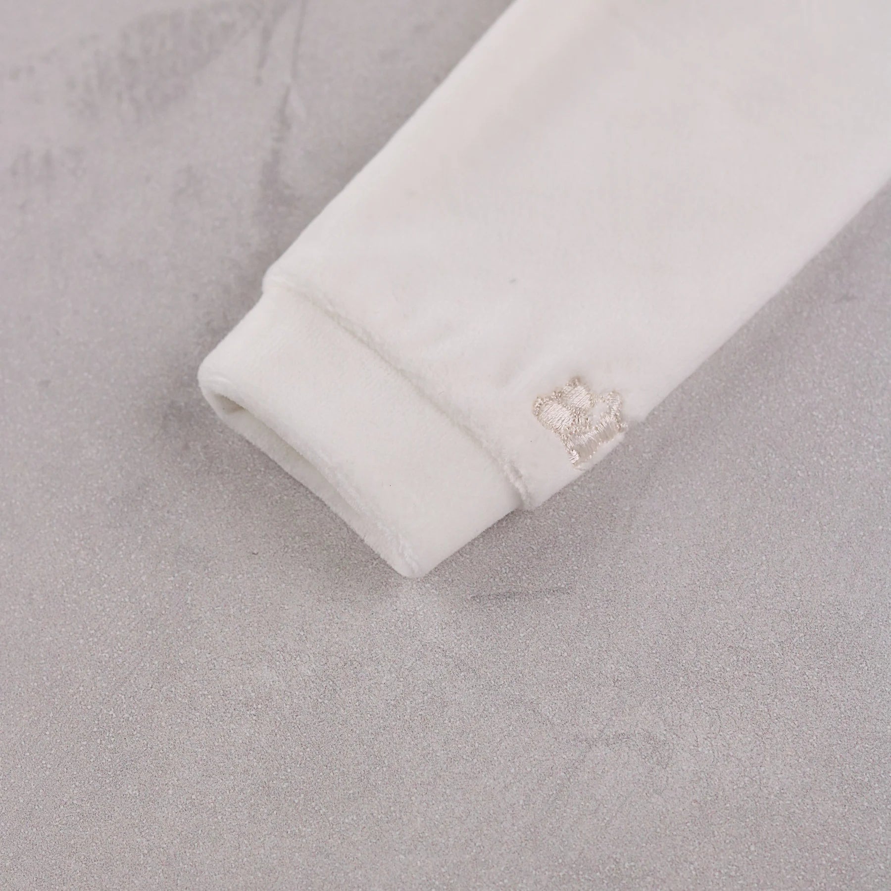 Close-up of the soft ivory velour sleeve cuff on the Emile et Rose Marshall romper