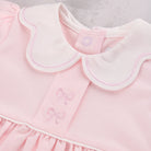 Close-up of a Emile et Rose Maggie baby dress in soft pink with a white Peter Pan collar