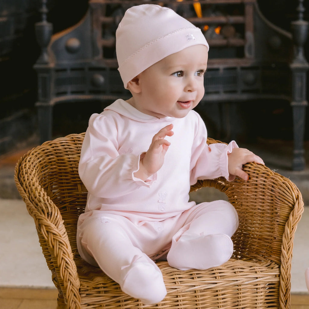 Baby girl sitting in basket wearing Emile et Rose Kallie Pink Bunny Babygrow & Hat