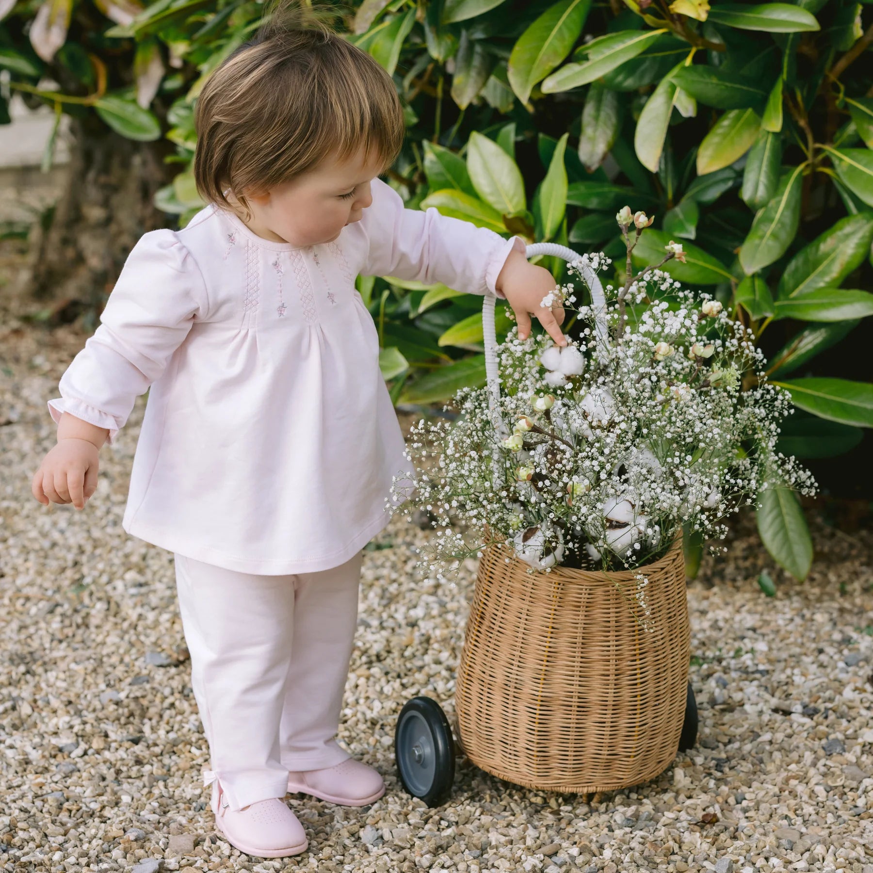Baby girl standing in Emile et Rose Kate pink top and trousers outfit set