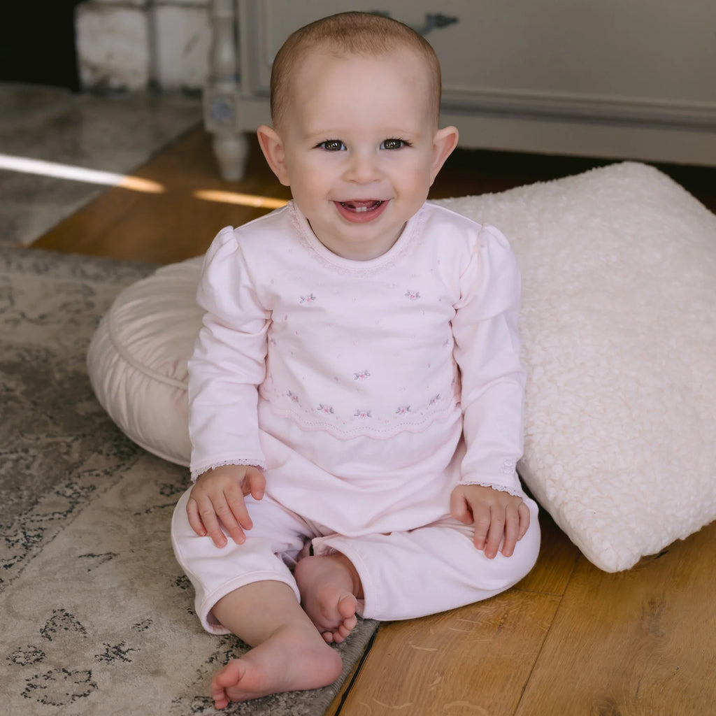Baby girl wearing Emile et Rose Katerina pink babygrow and hairband set.