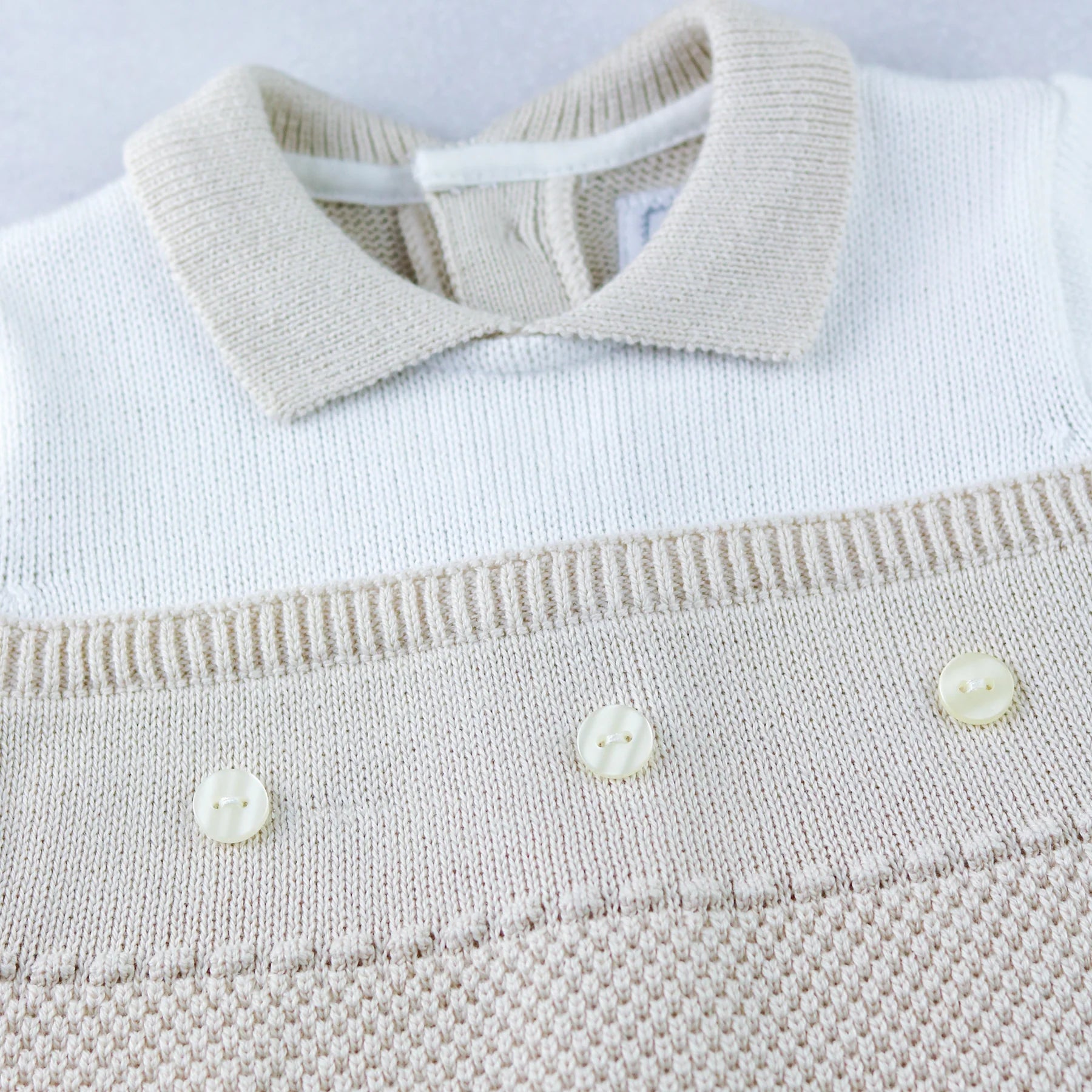 Close-up of collar and pearlised buttons on Emile et Rose Kenzie babygrow