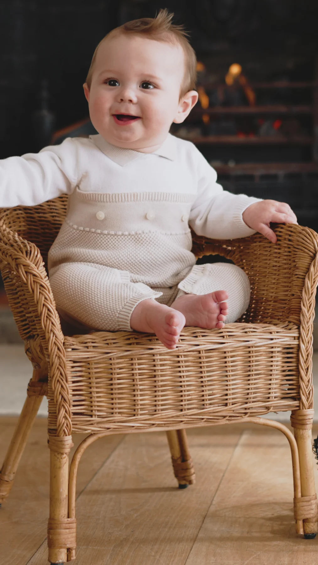Baby boy or girl wearing Emile et Rose Kenzie knitted babygrow with pearl buttons