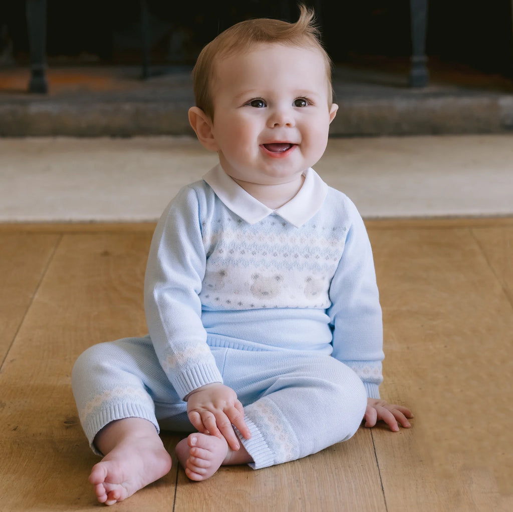 Baby boy wearing Emile et Rose Kipling blue knitted teddy outfit and hat.