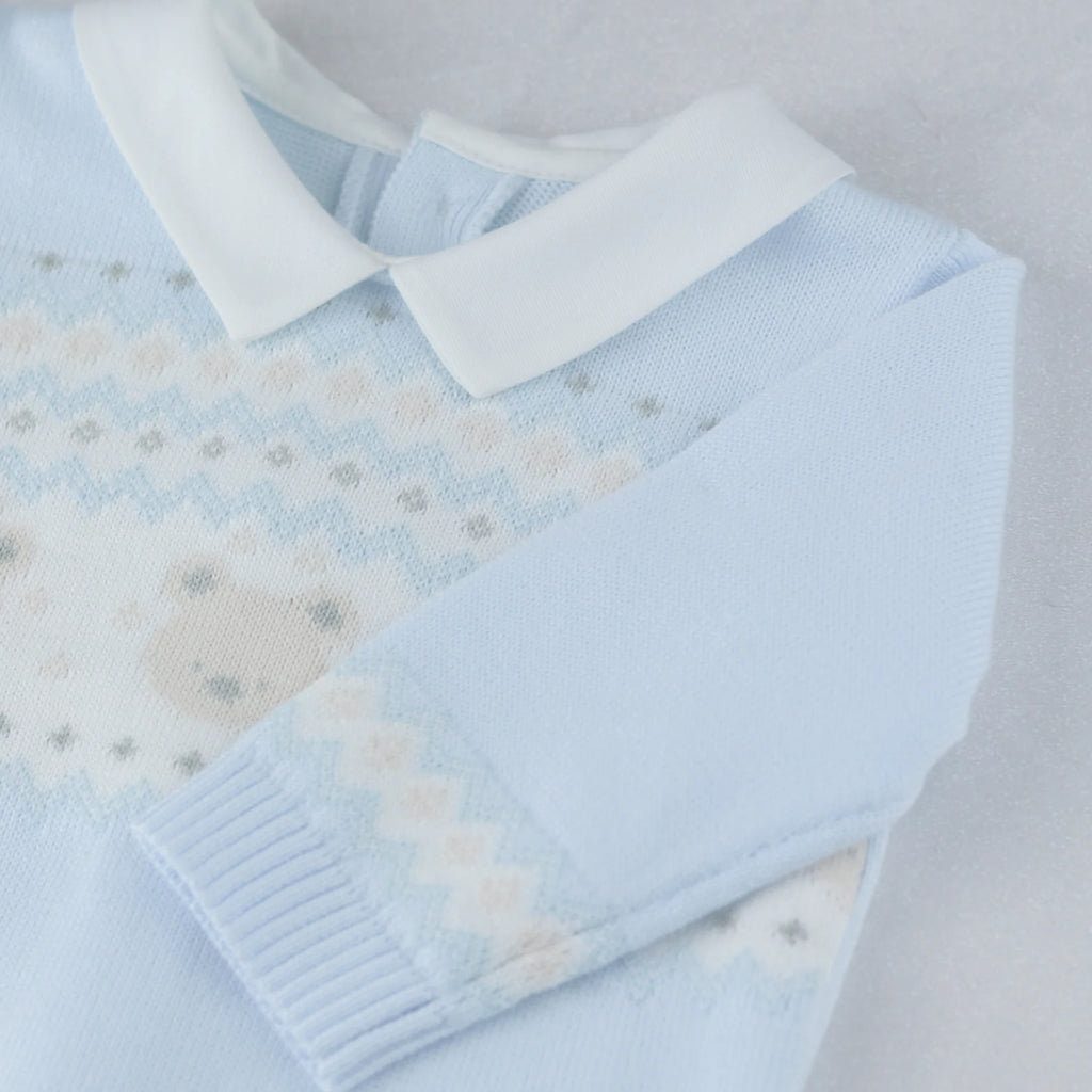 Baby boy seated with toy horse in Emile et Rose Kipling blue knitted occasion outfit.
