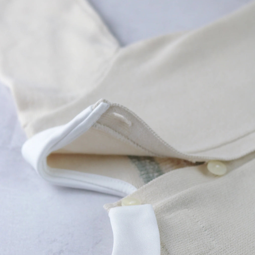 Collar and button detail of Emile et Rose Kipling teddy knit baby top.
