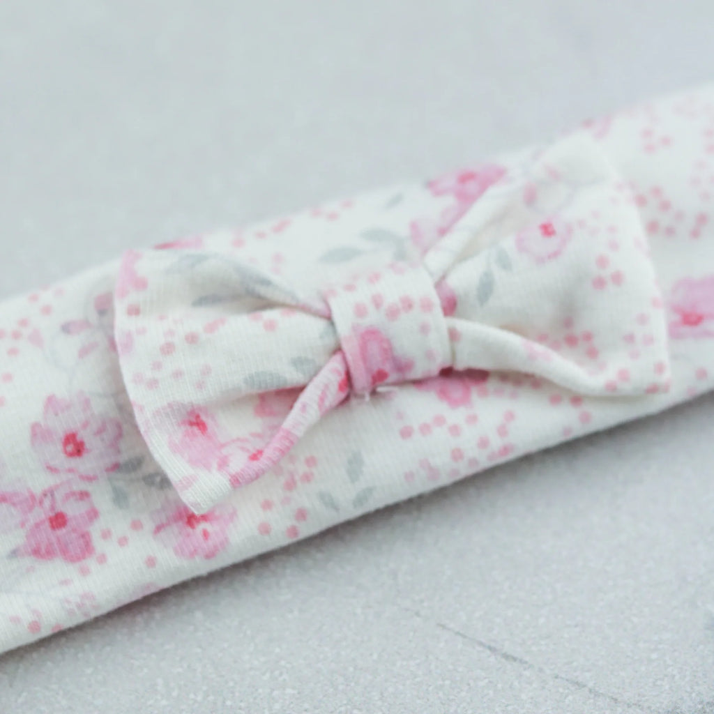 Flatlay of Emile et Rose Kylie girls floral print babygrow with hairband
