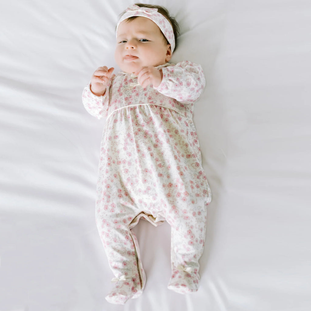 Baby girl wearing Emile et Rose Kylie floral print babygrow and hairband set