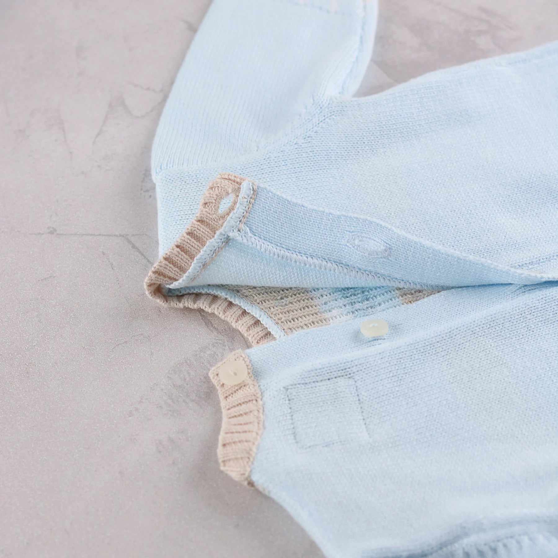 Close-up of Emile et Rose Martin knitted outfit set back button detail 