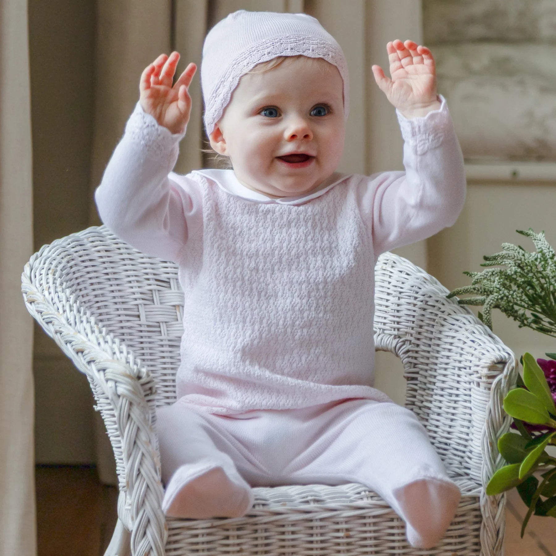  Baby wearing the Emile et Rose Minny pale pink baby girls knit outfit while sitting in a basket