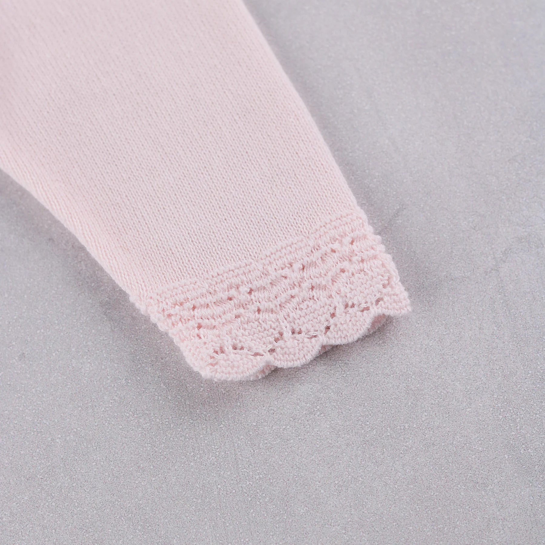 Close-up of the knitted pink lace cuff detail on the Emile et Rose Minny baby girls outfit