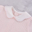 Close-up of the white scalloped collar with pink spot embroidery on the Emile et Rose Minny knit top