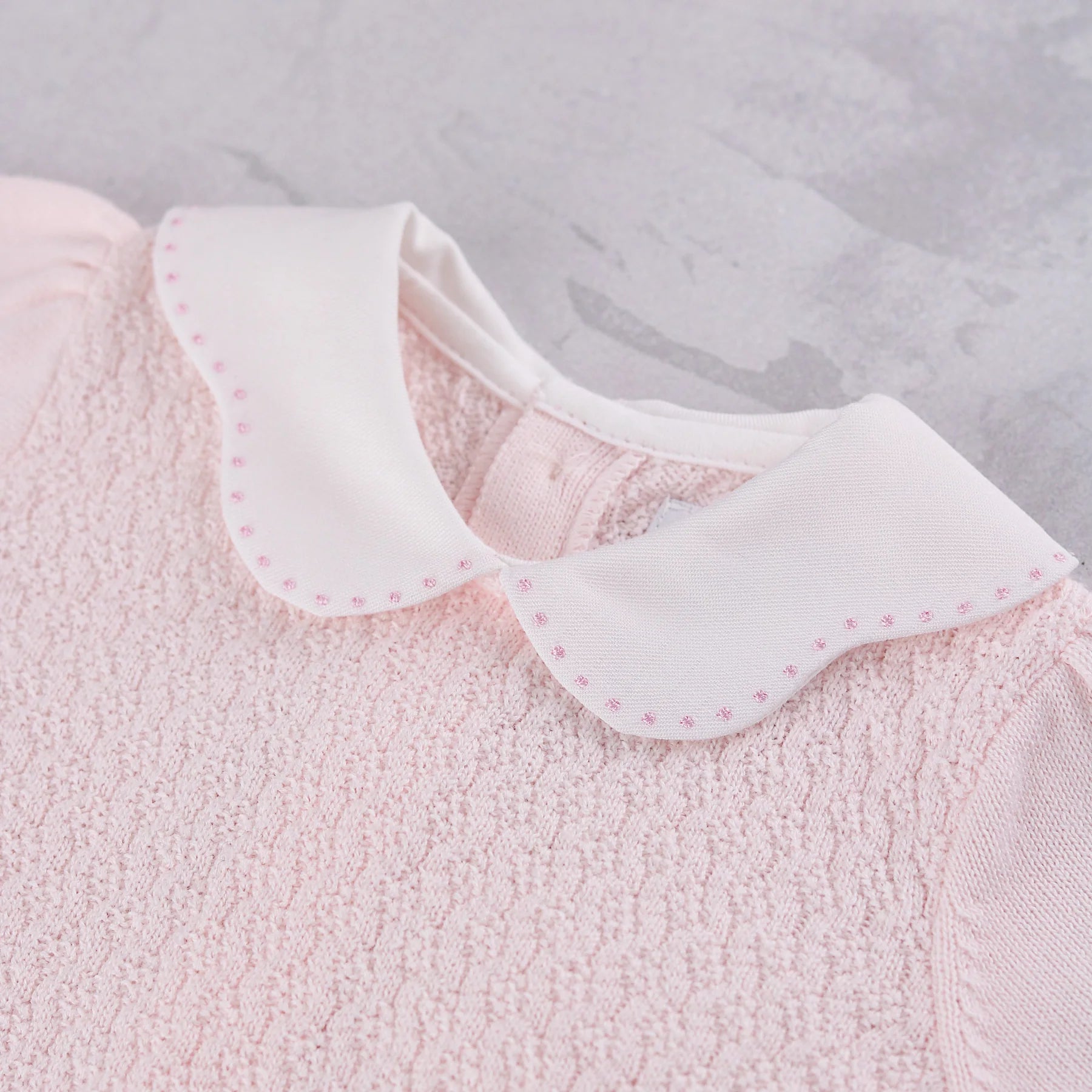 Close-up of the white scalloped collar with pink spot embroidery on the Emile et Rose Minny knit top