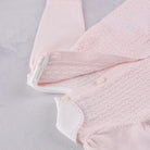 Close-up of the pearlised button fastening on the back of the Emile et Rose Minny knit top