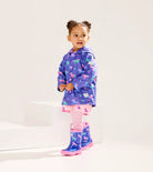 Toddler wearing Hatley Girls Hearts & Horses raincoat with matching boots – lifestyle
