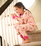 Cute girl wearing Hatley Little Kitties PJs on stairs with pink cat print