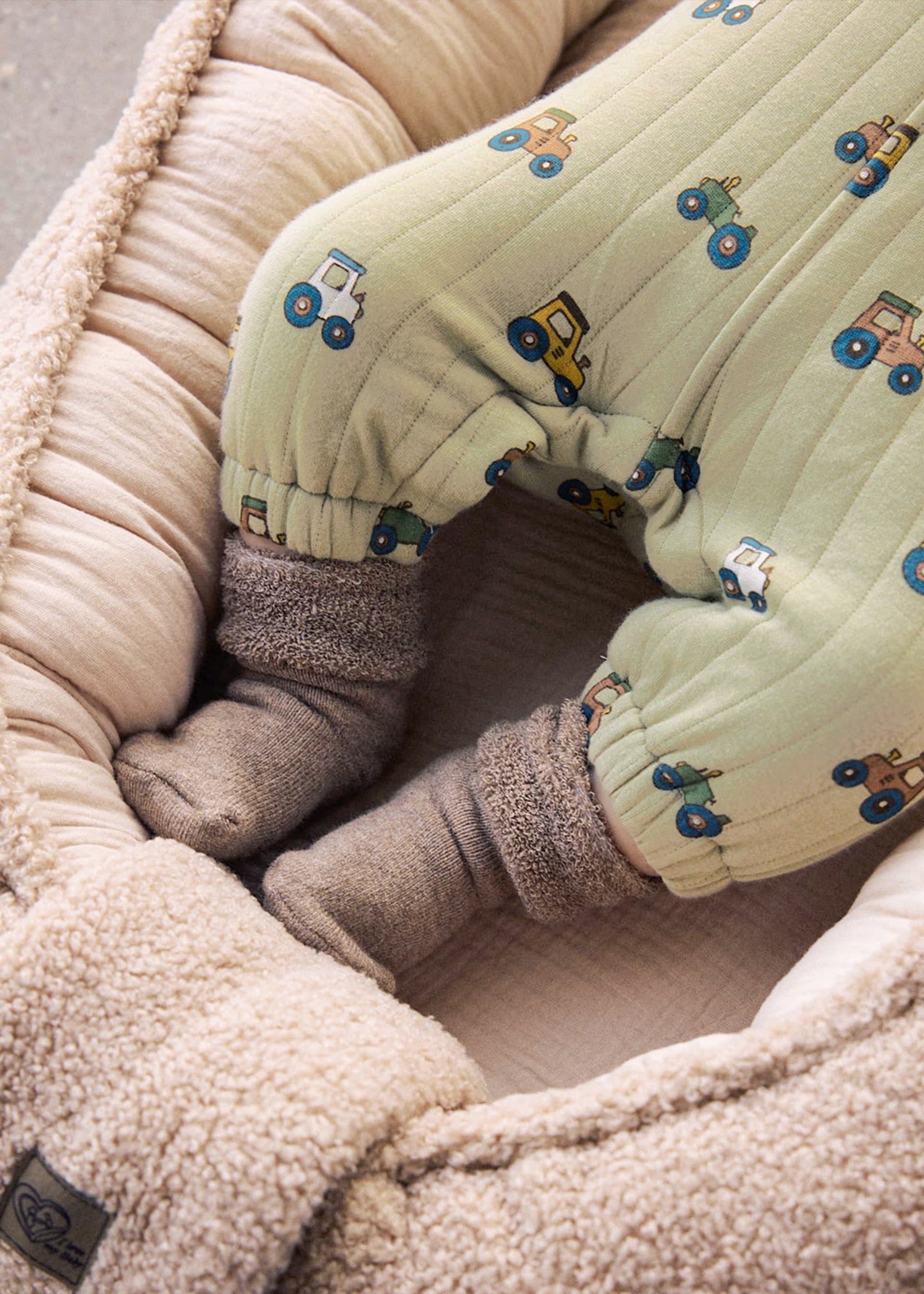     Close-up of Mayoral green tractor print baby dungarees with elasticated ankles