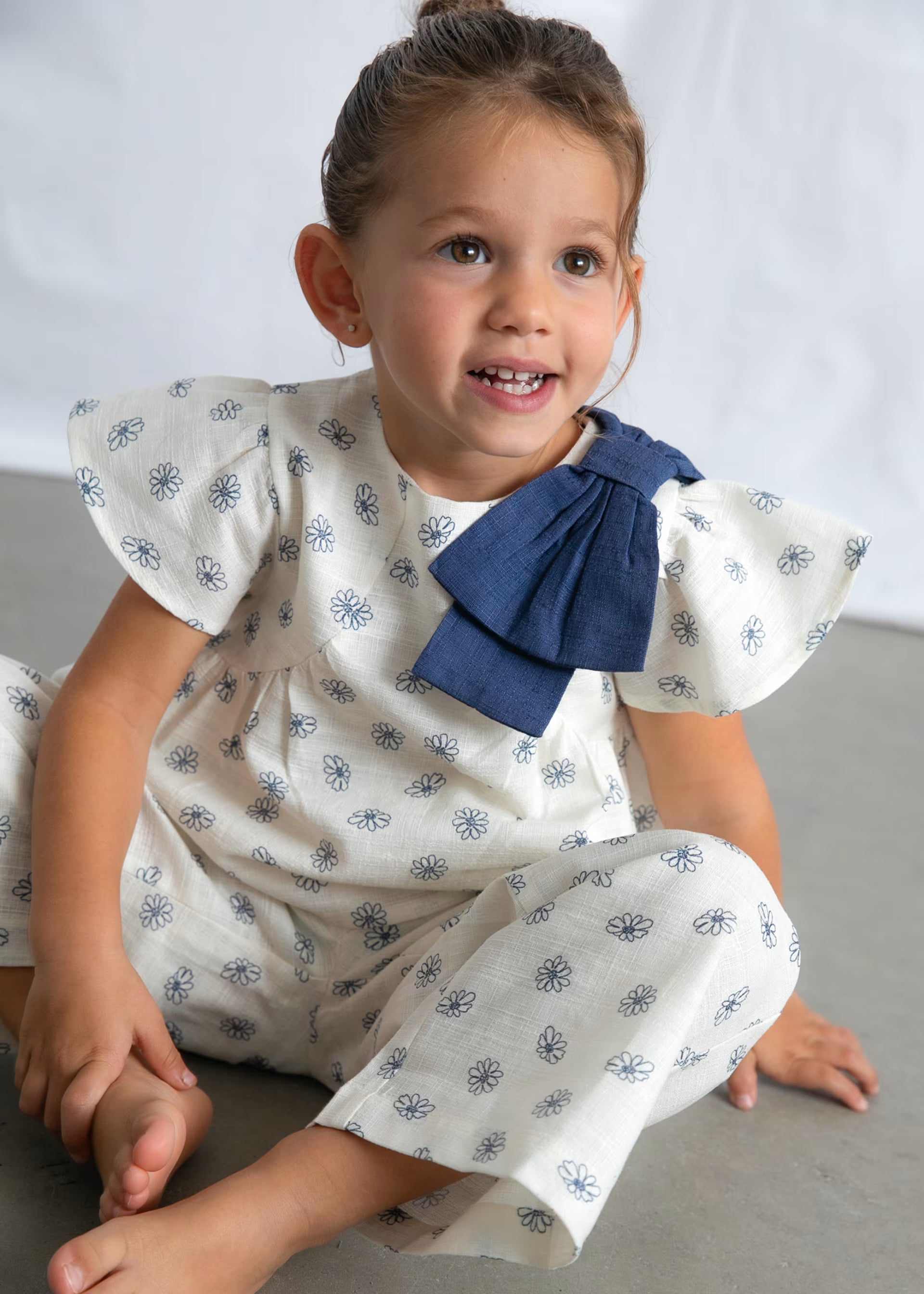 Mayoral girls daisy print outfit set worn close up blue bow detail