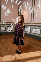 Girl wearing Patachou Balmoral navy and red tartan Christmas dress