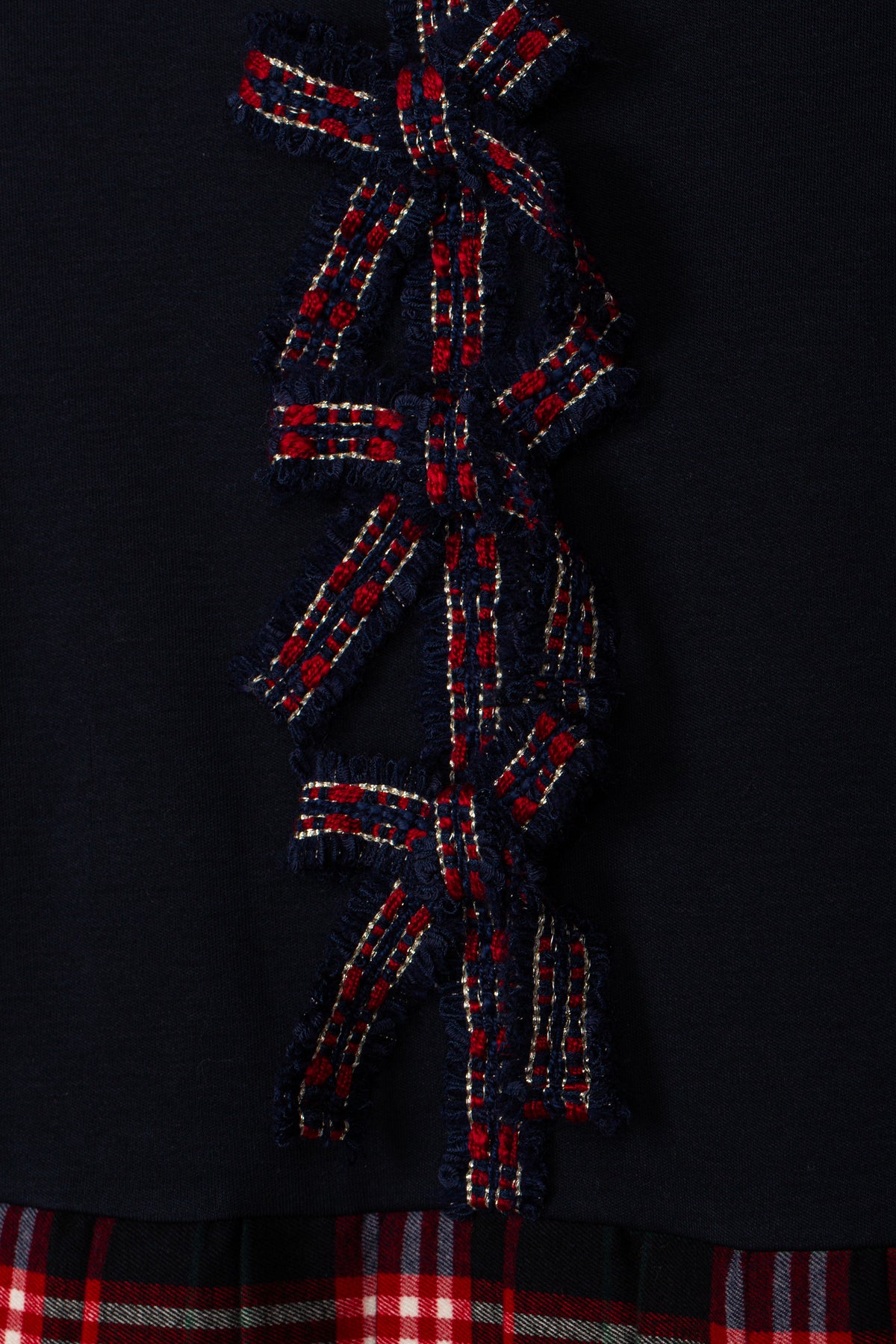 Close-up of Patachou navy Christmas dress with red tartan bow details