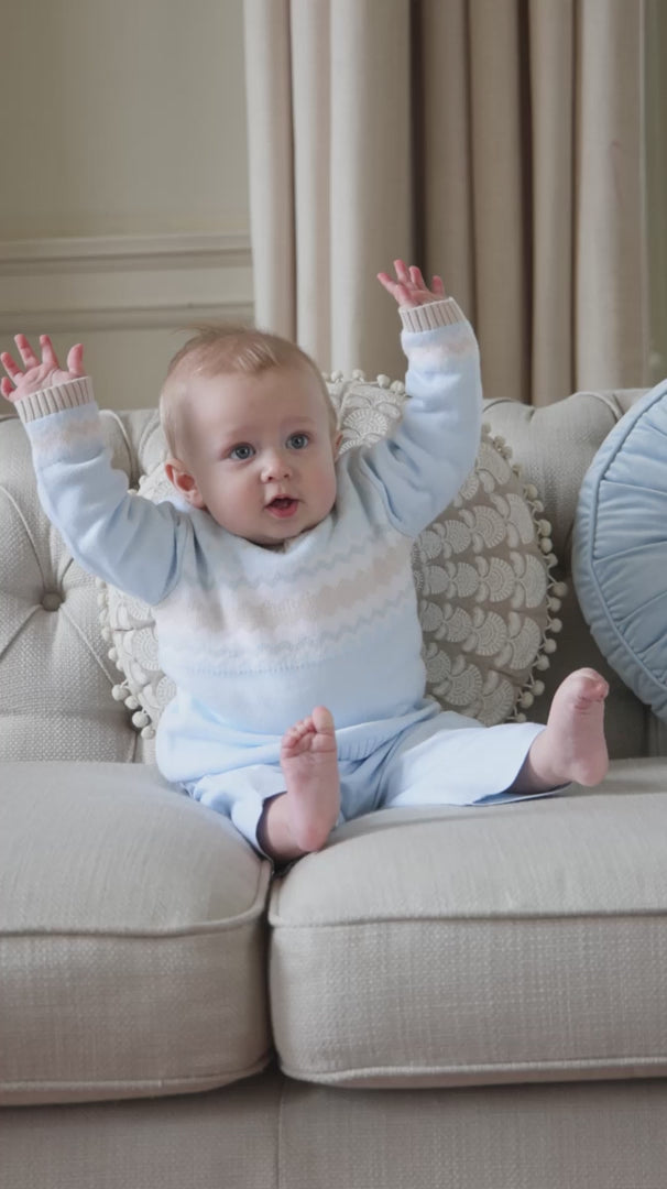 Baby boy wearing Emile et Rose Martin pale blue knitted outfit sitting