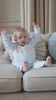Baby boy wearing Emile et Rose Martin pale blue knitted outfit sitting