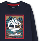 Close-up of Timberland tree logo on boys navy graphic long sleeve T-shirt