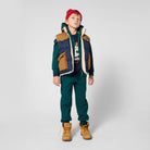 Boy wearing Timberland navy logo T-shirt with green trousers, padded gilet and tan boots