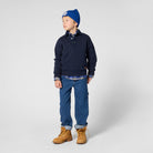 Boy wearing Timberland navy polo collar sweatshirt with blue jeans and tan boots