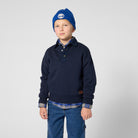 Boy wearing Timberland boys navy collared sweatshirt layered over a checked shirt