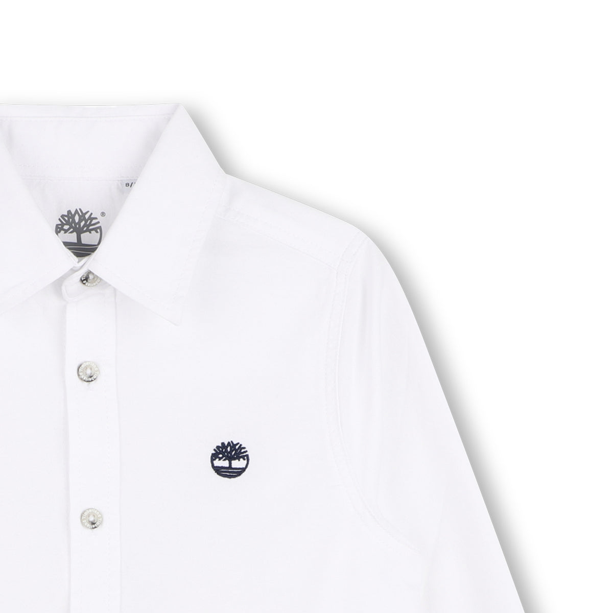Close-up of Timberland boys white shirt showing collar, buttons and embroidered tree logo