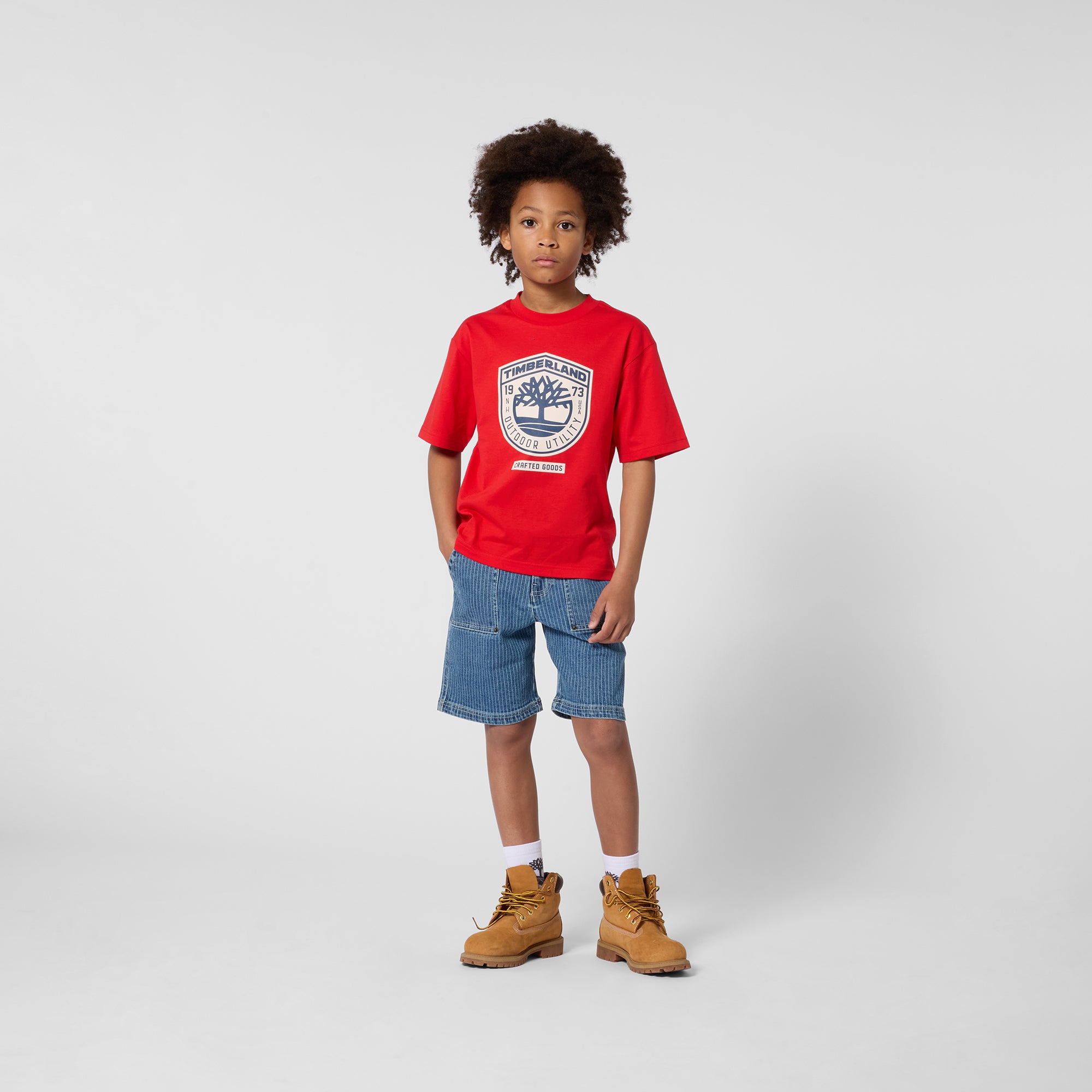 Timberland boys red T-shirt styled with denim shorts