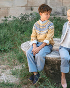 Boy wearing Tutto Piccolo mustard knitted jumper and blue shirt outfit