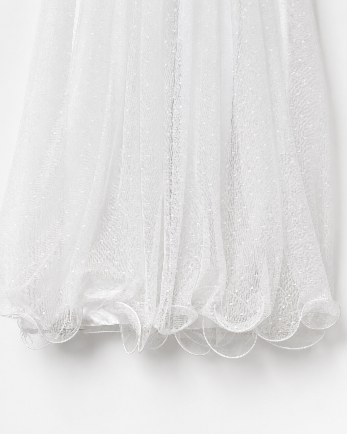     Close-up of the curled tulle hem on the Visara baby girls christening gown