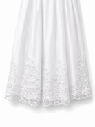 Close-up of the ornate floral lace embroidered hem on the Visara white christening gown