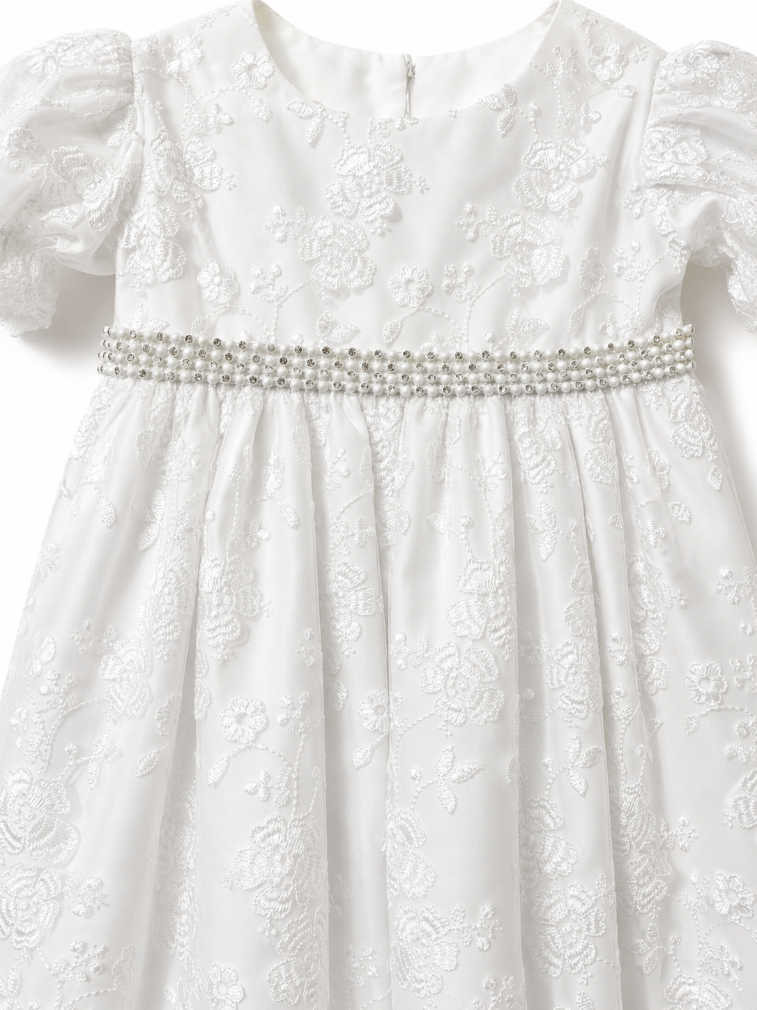 Close-up of the floral embroidery and pearl and diamante waist trim on the Visara christening gown
