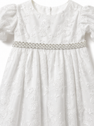 Close-up of the floral embroidery and pearl and diamante waist trim on the Visara christening gown