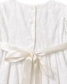 Close-up of the floral sequin embroidery, back buttons and satin bow on the Visara christening gown